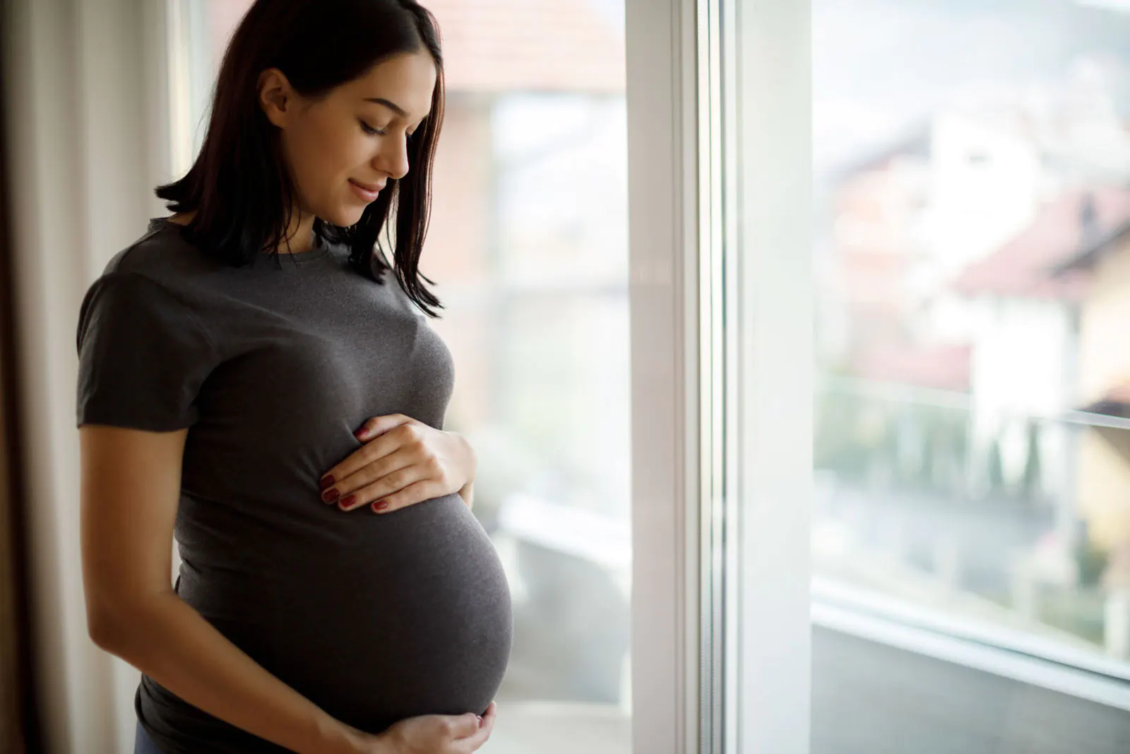 YWCA prenatal services-pregnant mother smiling and holding belly